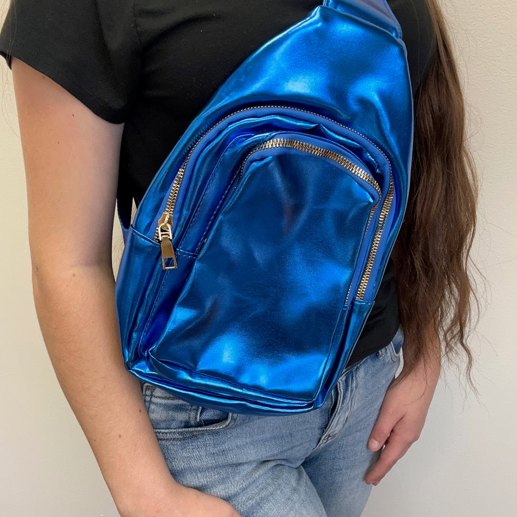 Person wearing a shiny blue backpack with gold zippers.