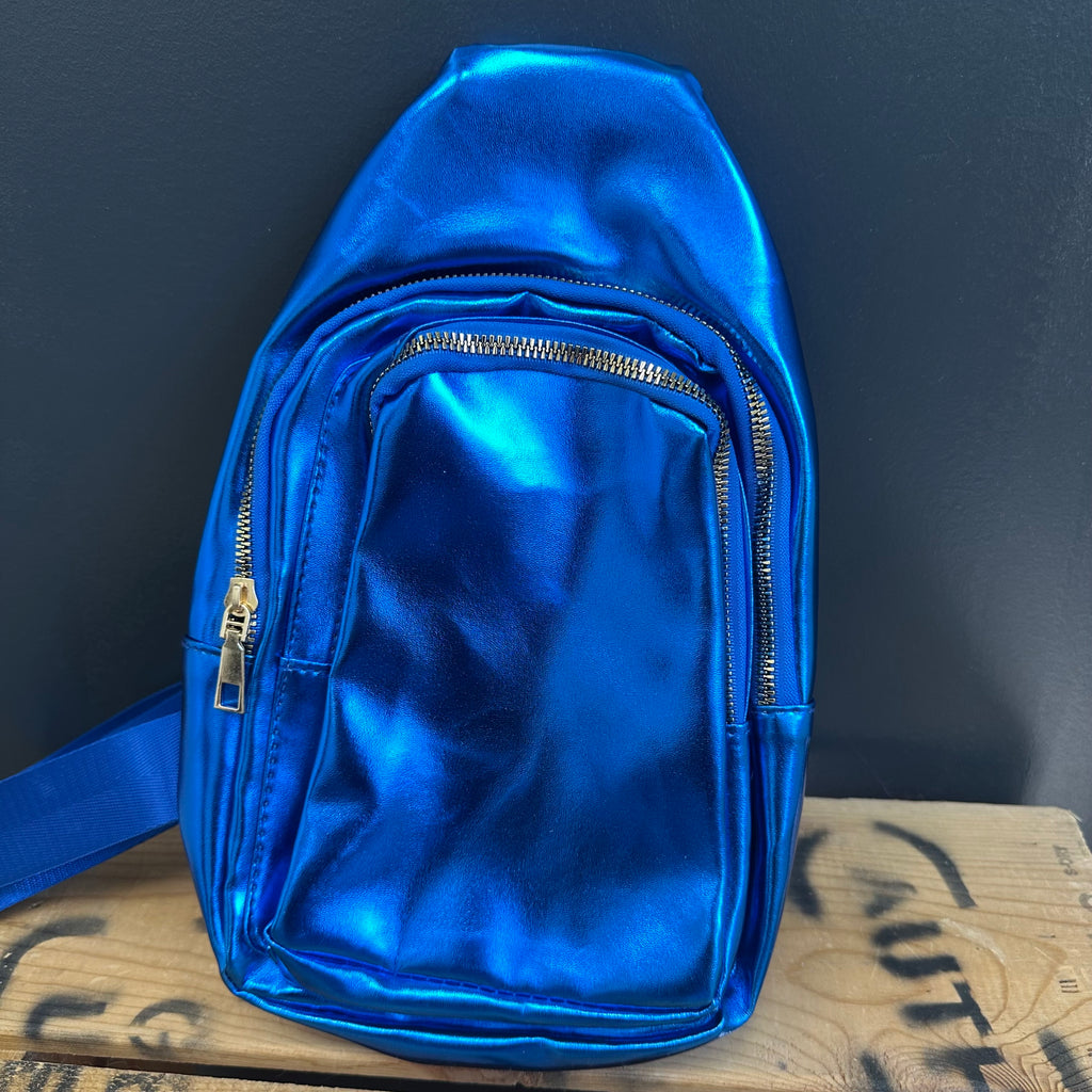 Blue metallic backpack on a wooden surface with a dark background