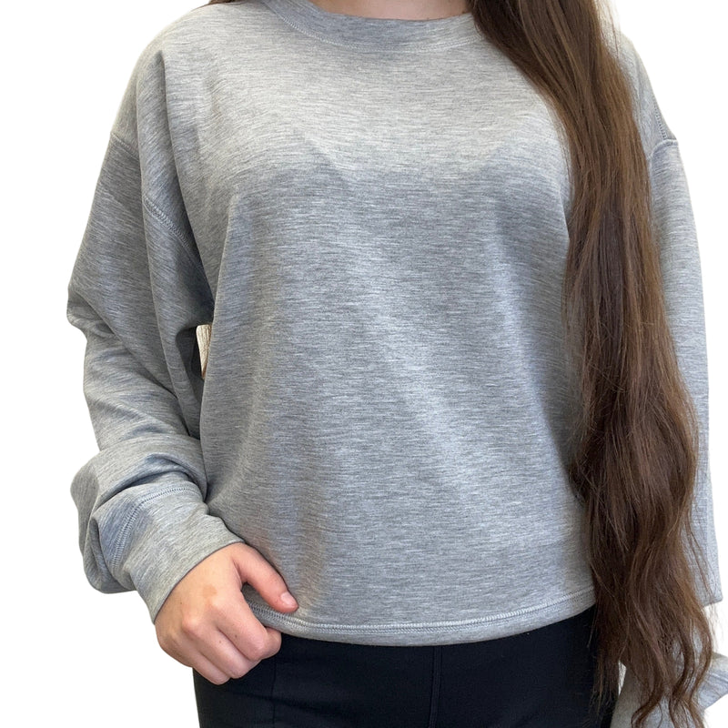Person wearing a gray sweatshirt against a plain background