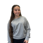 Person wearing a gray sweatshirt against a plain background