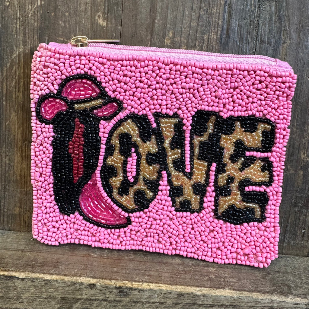 Pink beaded pouch with 'LOVE' in leopard print letters on a wooden surface