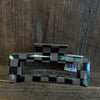 Checkered patterned object with 'APC' label on a wooden surface