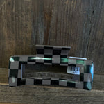 Checkered patterned object with 'APC' label on a wooden surface