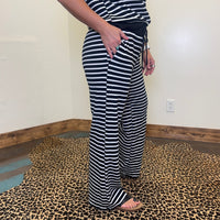 Person wearing black and white striped pants and shirt in a room with a leopard print floor.