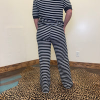 Person wearing a black and white striped outfit on a leopard print floor.
