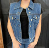blue denim vest over a black top against a dark background