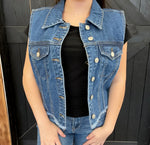 blue denim vest over a black top against a dark background