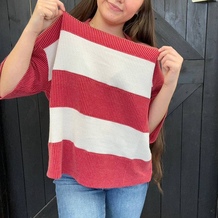 red and white striped sweater against a black wooden background