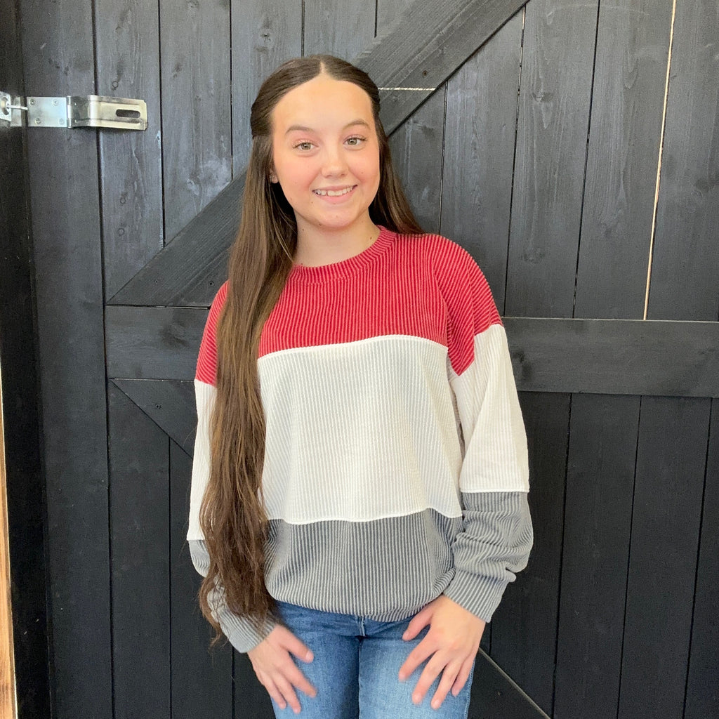 red, white, and gray sweater standing 