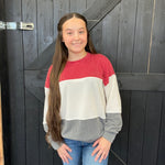red, white, and gray sweater standing 