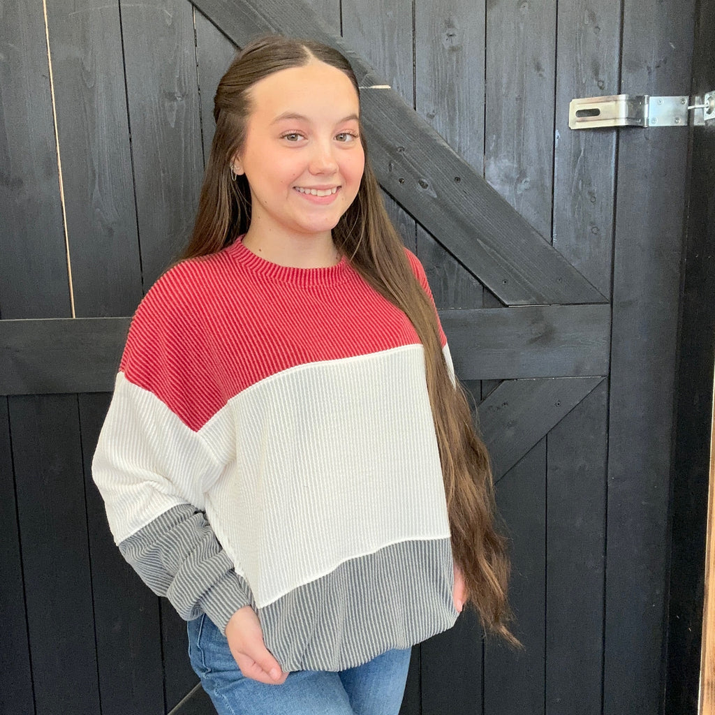 red, white, and gray sweater standing in 