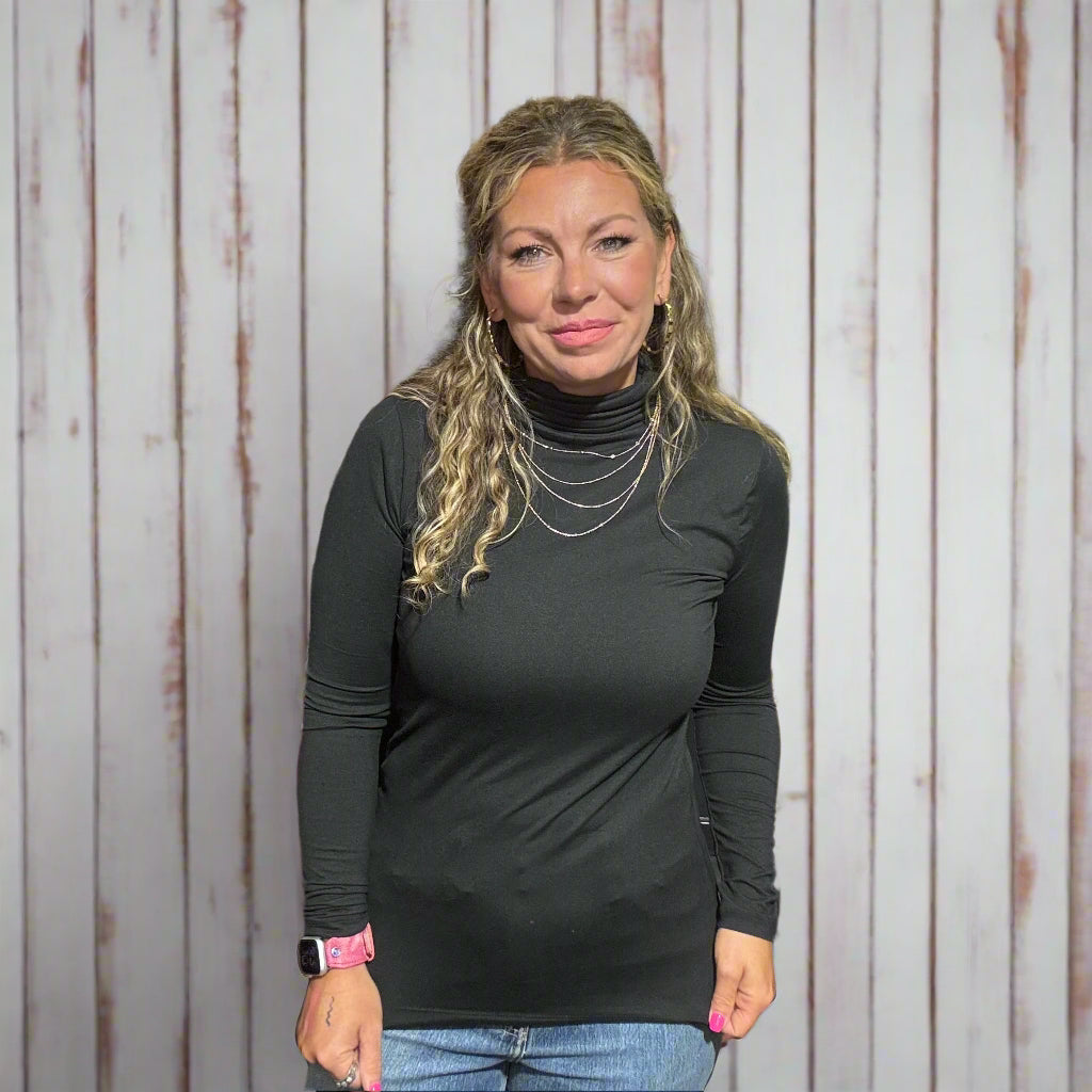 Woman standing in a clothing store with racks and a yellow chair in the background.