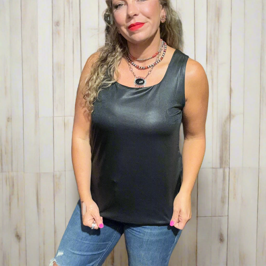 Woman wearing a black sleeveless top and blue jeans standing in a clothing store.