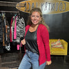 Woman standing in front of a clothing rack with a 'Country Ace' sign in the background
