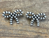 Pair of silver bow-shaped earrings on a wooden surface