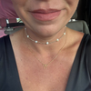 Close-up of a person wearing two necklaces with a blurred background