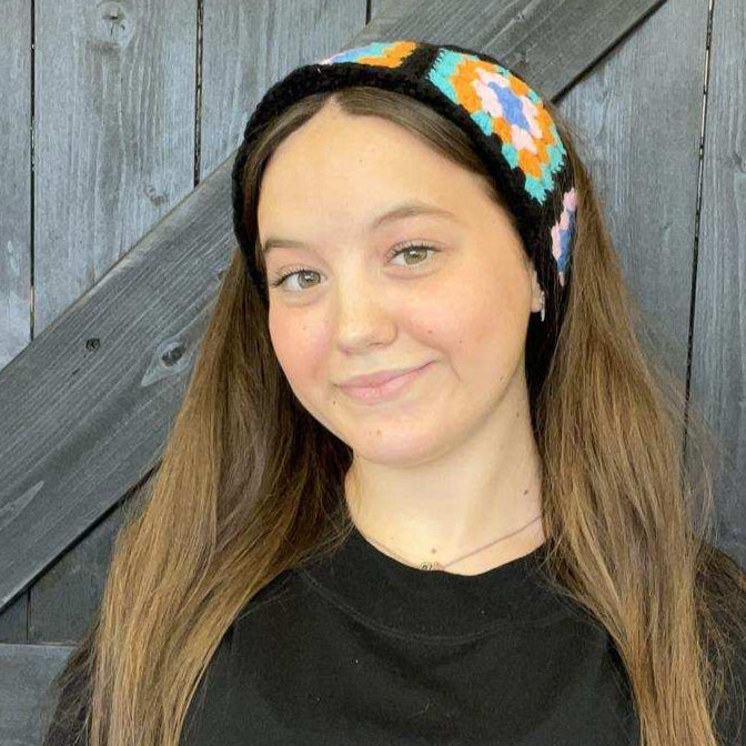 Person wearing a colorful headband with a wooden background