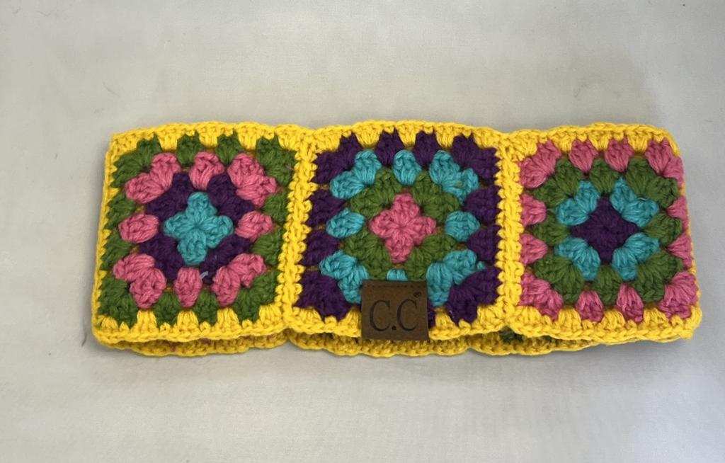 Crocheted wallet with colorful square patterns on a light gray background