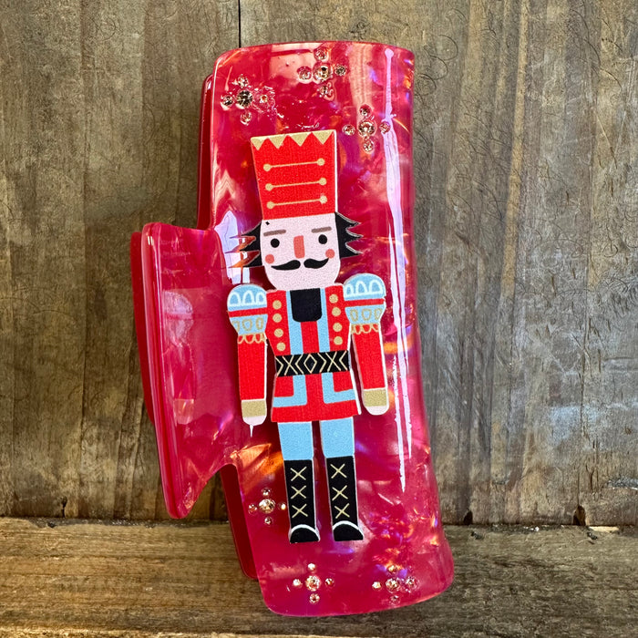 Decorative red boot with a nutcracker design on a wooden background