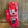 Decorative red boot with a nutcracker design on a wooden background