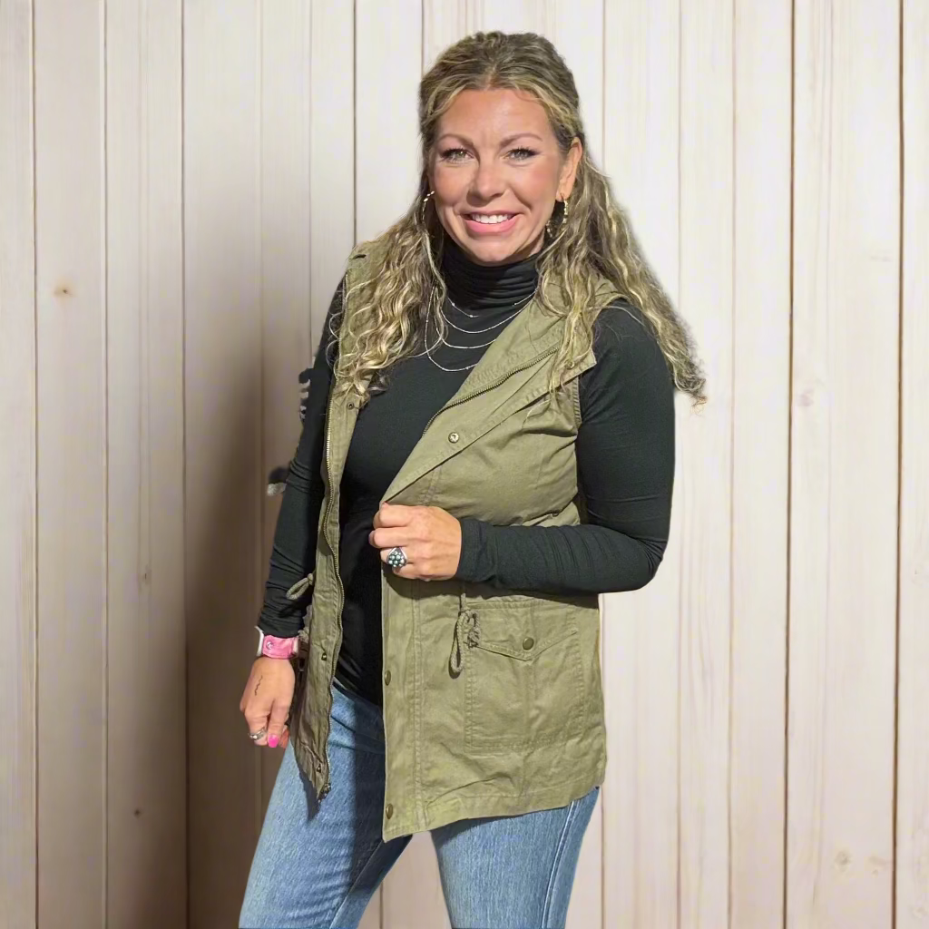 Woman standing in a clothing store with clothes and a yellow chair in the background