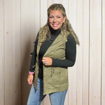 Woman standing in a clothing store with clothes and a yellow chair in the background